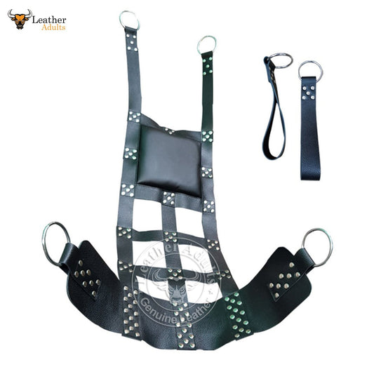 A black leather sex swing sling with stirrups, O-rings, and a cushioned area. The sling is designed for adult play and includes metal studs for added texture.