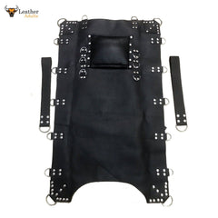 A black leather sling swing hammock with metal rivets and a leather pillow, designed for adult play.