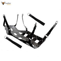 A black leather sex swing with stirrups, designed for adult use. The swing is made from thick leather with a patterned design and nickel-plated rivets, and includes straps for mounting or suspension.