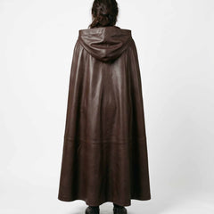 Direct rear view of woman wearing handmade brown cowhide leather hooded cloak showing center back seam and wide flowing hem