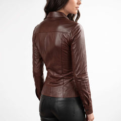 Rear three quarter perspective of a model showcasing the tailored waist fit and curved bottom hem of a brown genuine leather shirt.