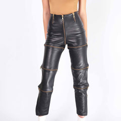 Close up front view of black leather convertible pants highlighting high waist gold zippers and textured leather panels