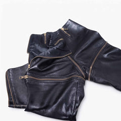 Close up flat lay detail of black leather zip off trousers displaying antique gold metal teeth, zipper pulls, and satin lining