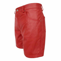 Three-quarter front angle of men's long red leather shorts showcasing smooth leather texture, front coin pocket, and clean hemmed leg openings.