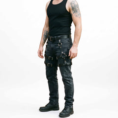 Full length studio shot of athletic man in black tank top and denim jeans wearing handcrafted black leather thigh harness with combat boots