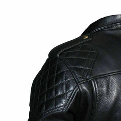 Close-up detail of the diamond-quilted shoulder panel, snap epaulette, and natural grain texture on a men's black cowhide leather jacket.