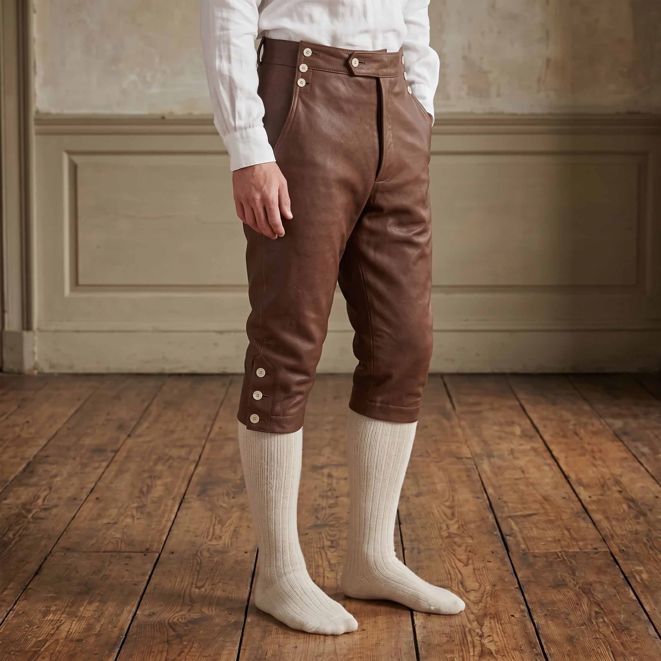 Side profile angle of men brown cowhide leather colonial knee breeches showing buttoned knee cuffs and high fall front waistband
