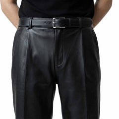 Close-up front view of men's genuine black lambskin leather formal pants featuring pleated front detailing and a classic leather belt.