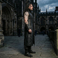 Side profile shot of tailored long black leather vest showing sleeveless armhole cut, studded chest pocket, and outer thigh eyelet lacing