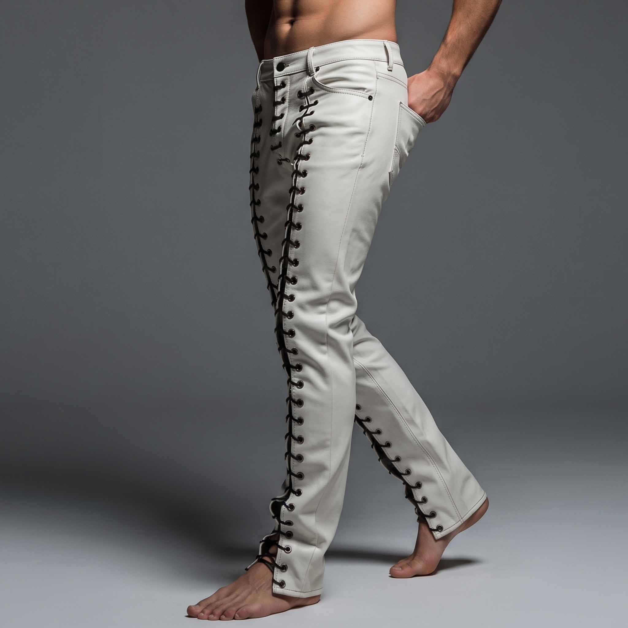 Side view of man walking in white leather lace up trousers highlighting hand in pocket and contrast black lacing along thighs and calves