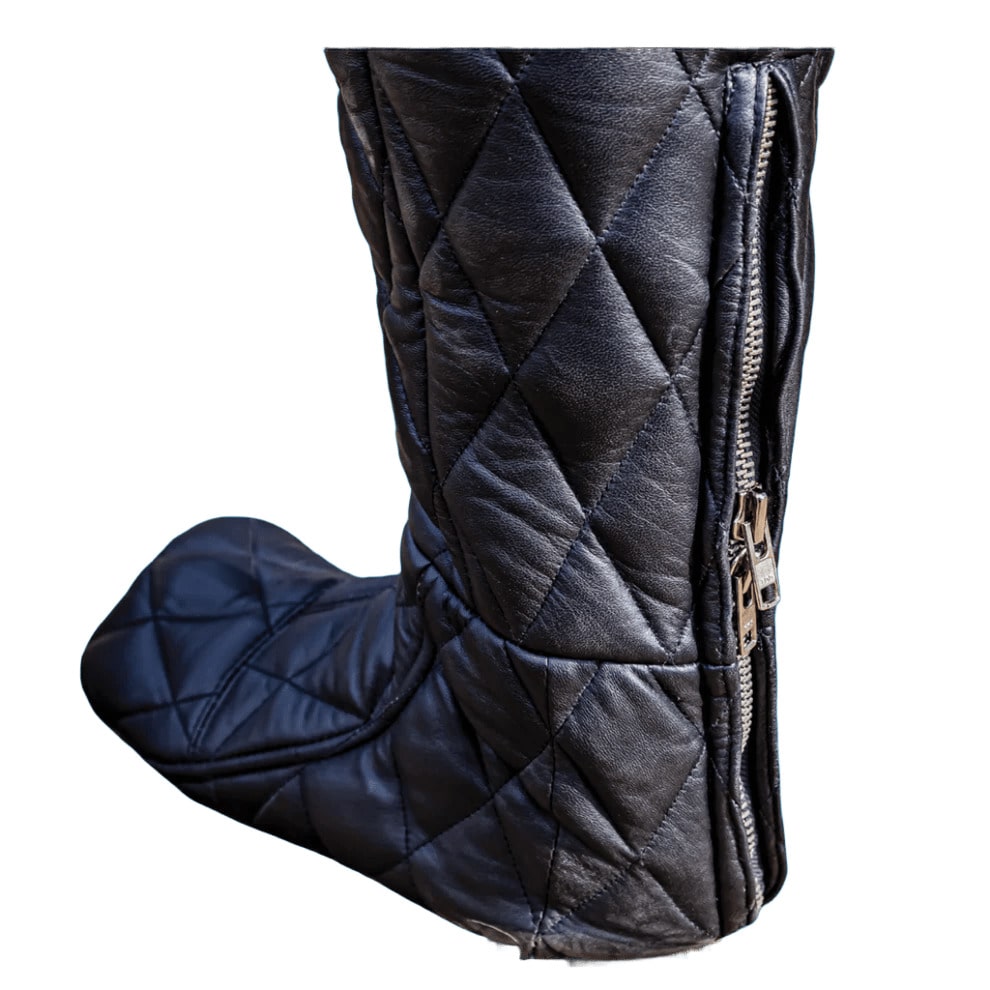 Quilted black boot with a gold zipper on a white background