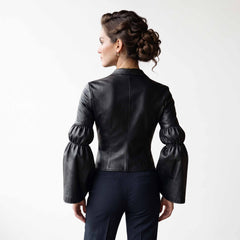Rear studio shot of black leather poet top on white background detailing smooth back paneling and voluminous gathered bell cuffs