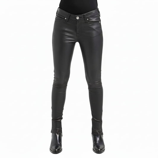 Black leather skinny pants shown on a model from the waist down, paired with a black top and black leather ankle boots, against a plain white background.