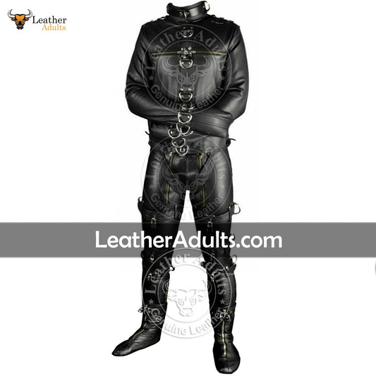 A man wearing a black leather bondage suit with D-rings, lacing, and straps for restraint, standing against a white background. The suit is embellished with silver and gold detailing, and the brand 'Leader Adults' is visible on the website address.