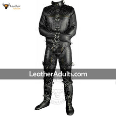 A man wearing a black leather bondage suit with D-rings, lacing, and straps for restraint, standing against a white background. The suit is embellished with silver and gold detailing, and the brand 'Leader Adults' is visible on the website address.